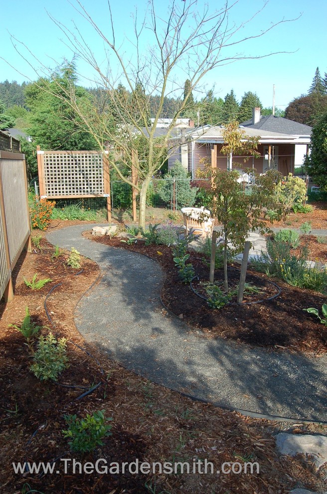 This is an example of a medium sized eclectic back full sun garden in Portland with a garden path and gravel.