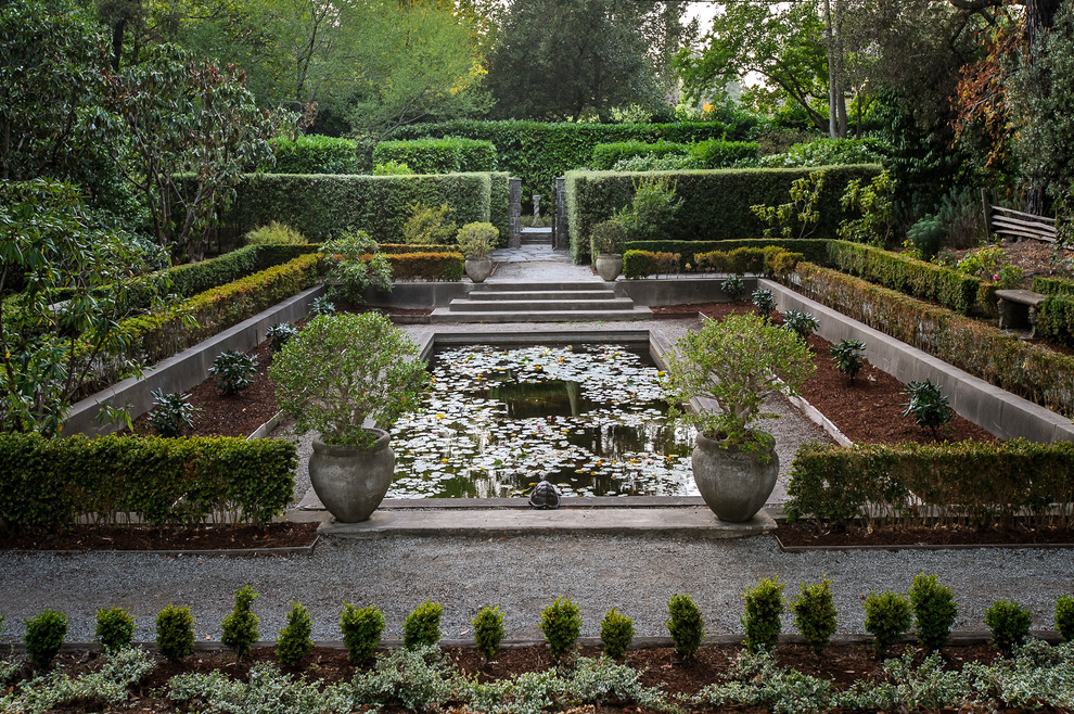 На фото: большой регулярный сад в классическом стиле с покрытием из гравия