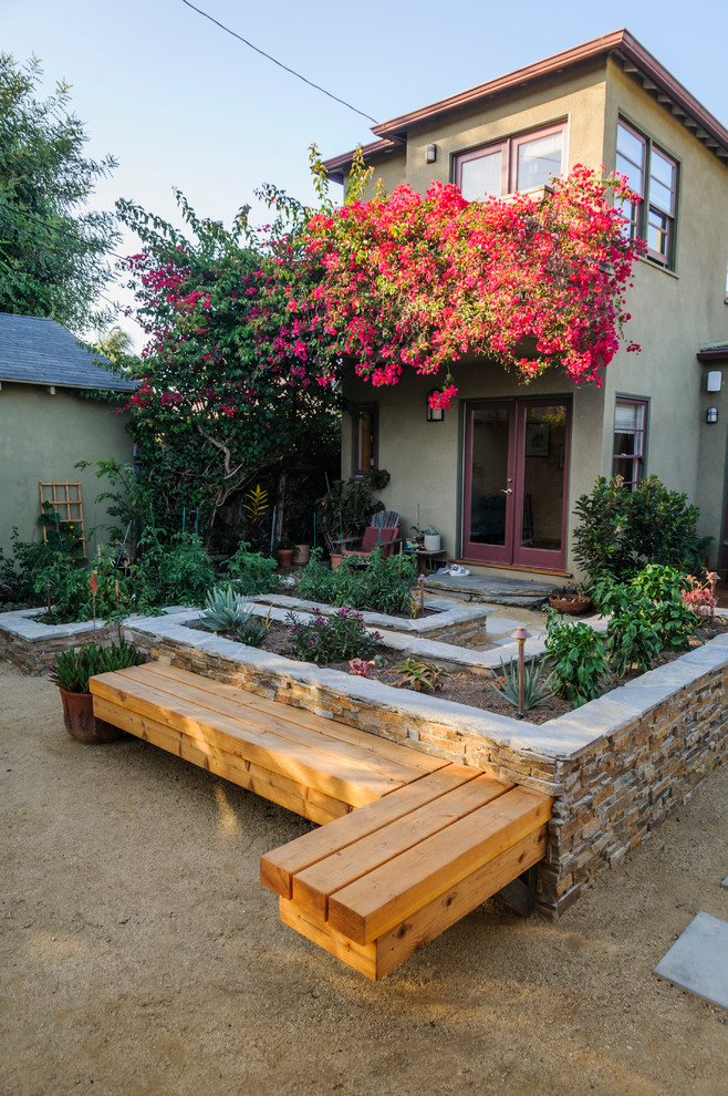 Diseño de jardín clásico de tamaño medio en primavera en patio trasero con gravilla, jardín francés y exposición parcial al sol