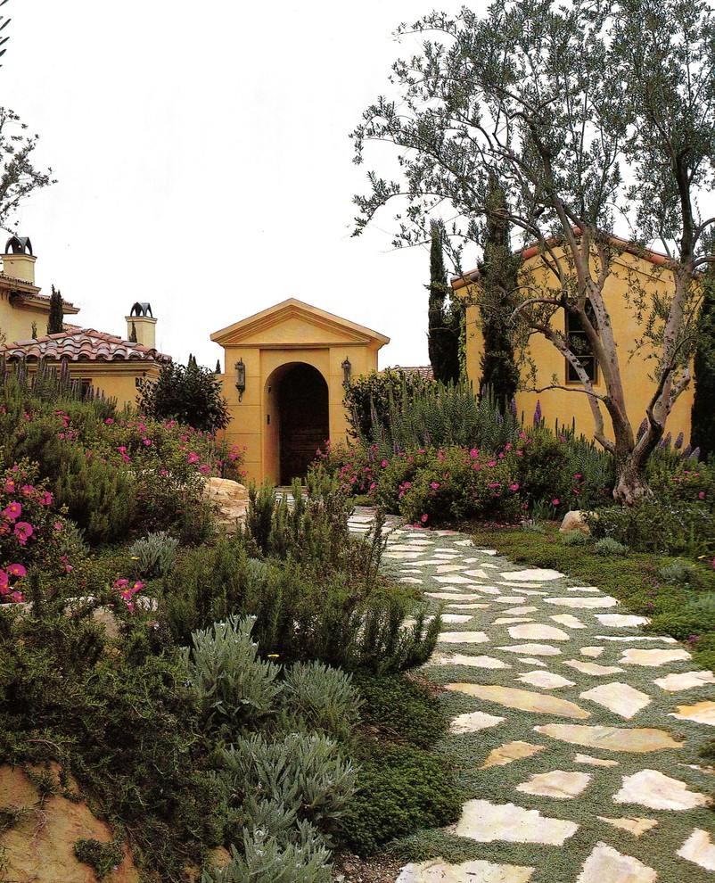 Foto di un giardino mediterraneo esposto in pieno sole con pavimentazioni in pietra naturale
