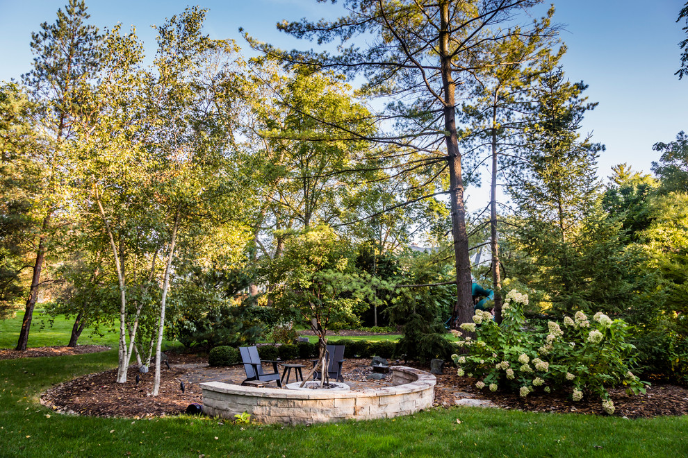 Immagine di un grande giardino american style esposto a mezz'ombra dietro casa con un focolare e pavimentazioni in cemento
