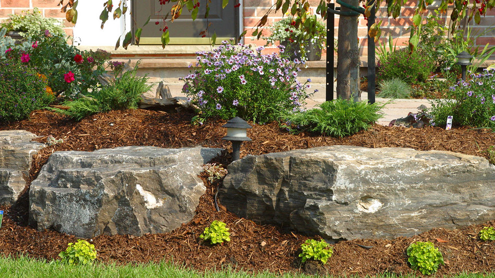 Design ideas for a medium sized traditional back partial sun garden in Toronto with a retaining wall and mulch.