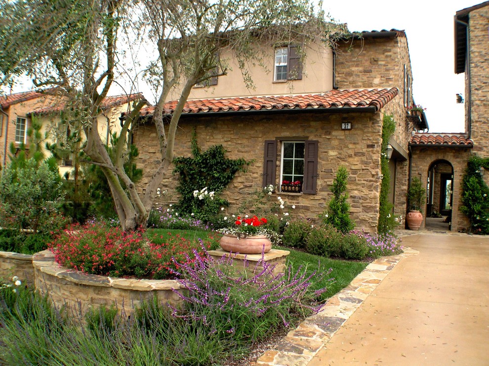 Design ideas for a medium sized mediterranean front partial sun garden in Los Angeles with natural stone paving.