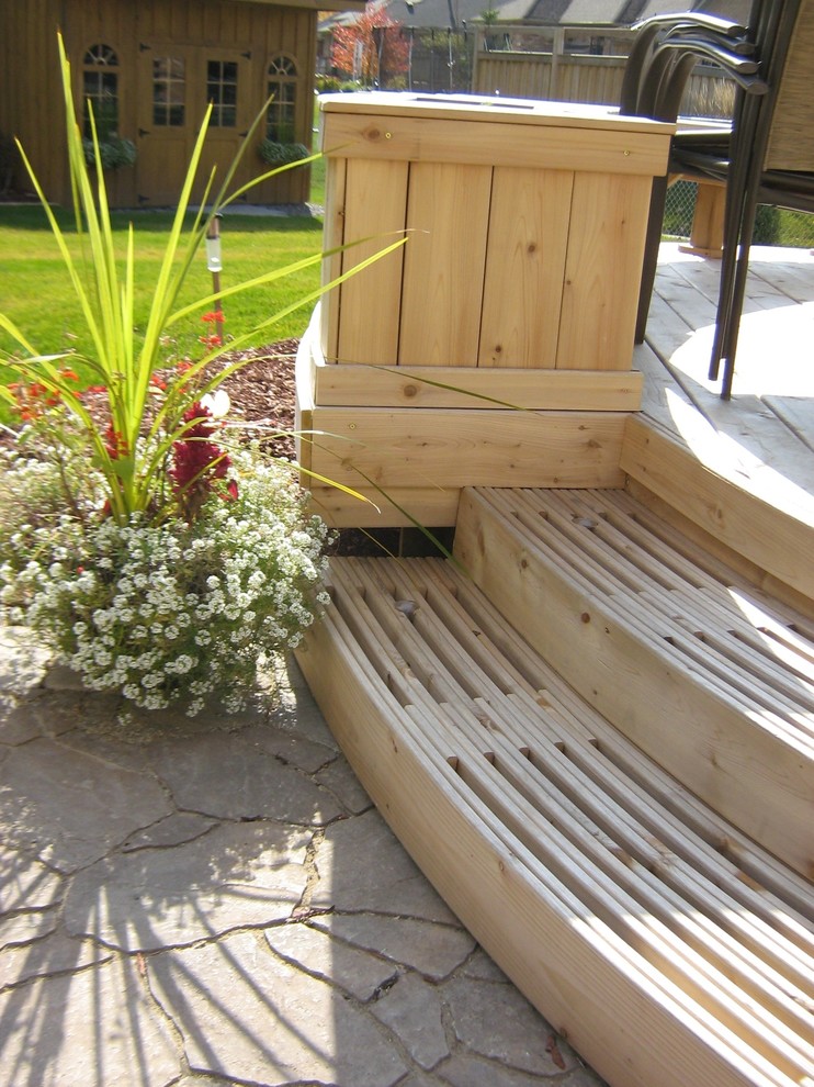 This is an example of a mid-sized contemporary backyard landscaping in Toronto with decking.