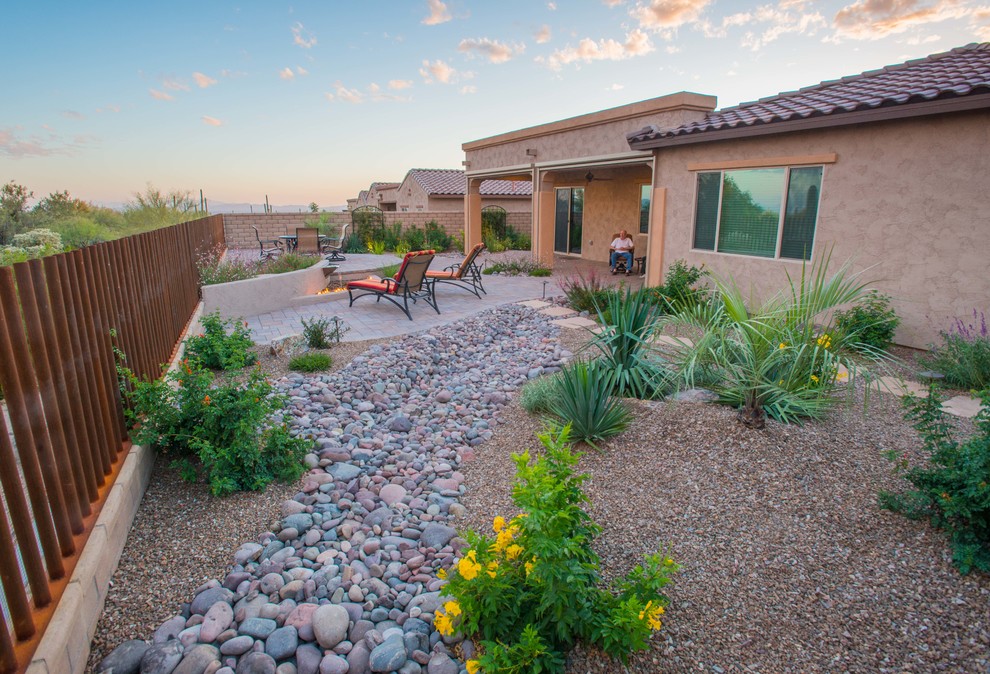 Inspiration for a medium sized back xeriscape partial sun garden for summer in Phoenix with a water feature and gravel.