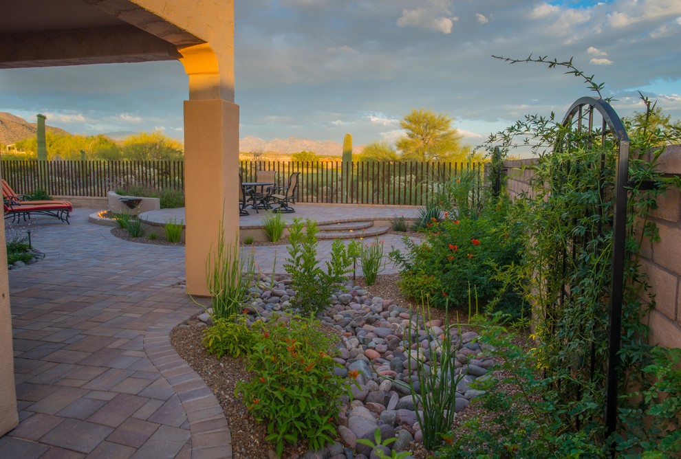 Immagine di un giardino xeriscape stile americano esposto a mezz'ombra di medie dimensioni e dietro casa in estate con fontane e pavimentazioni in mattoni