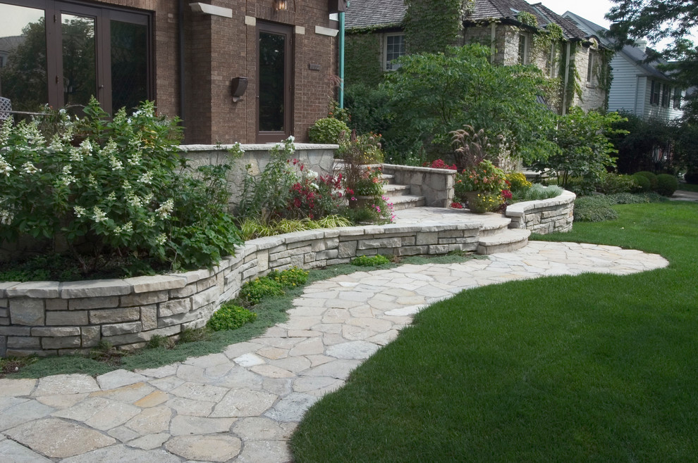 This is an example of a small eclectic front yard stone retaining wall landscape in Chicago.