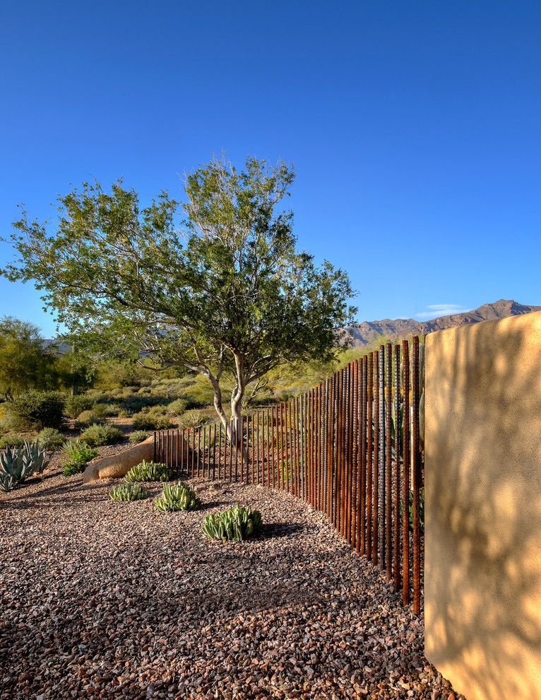 Geräumiger Mediterraner Garten im Sommer, hinter dem Haus mit Feuerstelle, direkter Sonneneinstrahlung und Natursteinplatten in Phoenix
