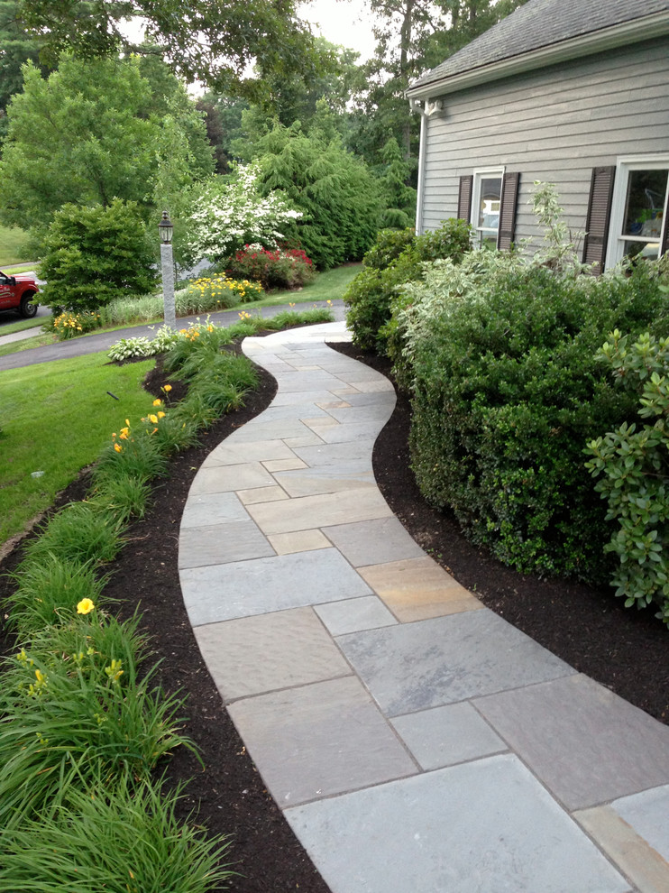 This is an example of a medium sized classic front driveway partial sun garden for spring in Boston with a garden path and concrete paving.