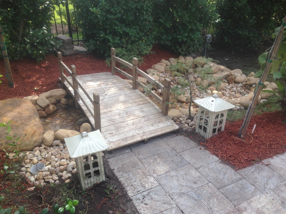 Photo of a medium sized world-inspired sloped xeriscape fully shaded garden in Jacksonville with a garden path and natural stone paving.