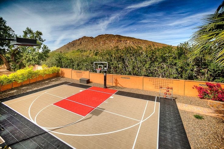 Foto di un grande campo sportivo esterno minimalista esposto in pieno sole dietro casa con uno spazio giochi