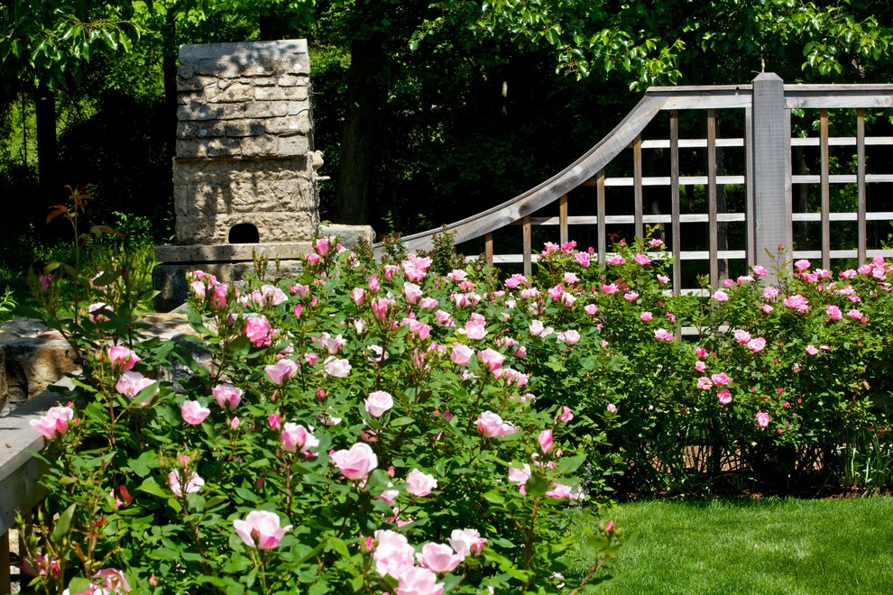Idée de décoration pour un grand jardin arrière tradition l'été avec une exposition ensoleillée et des pavés en brique.