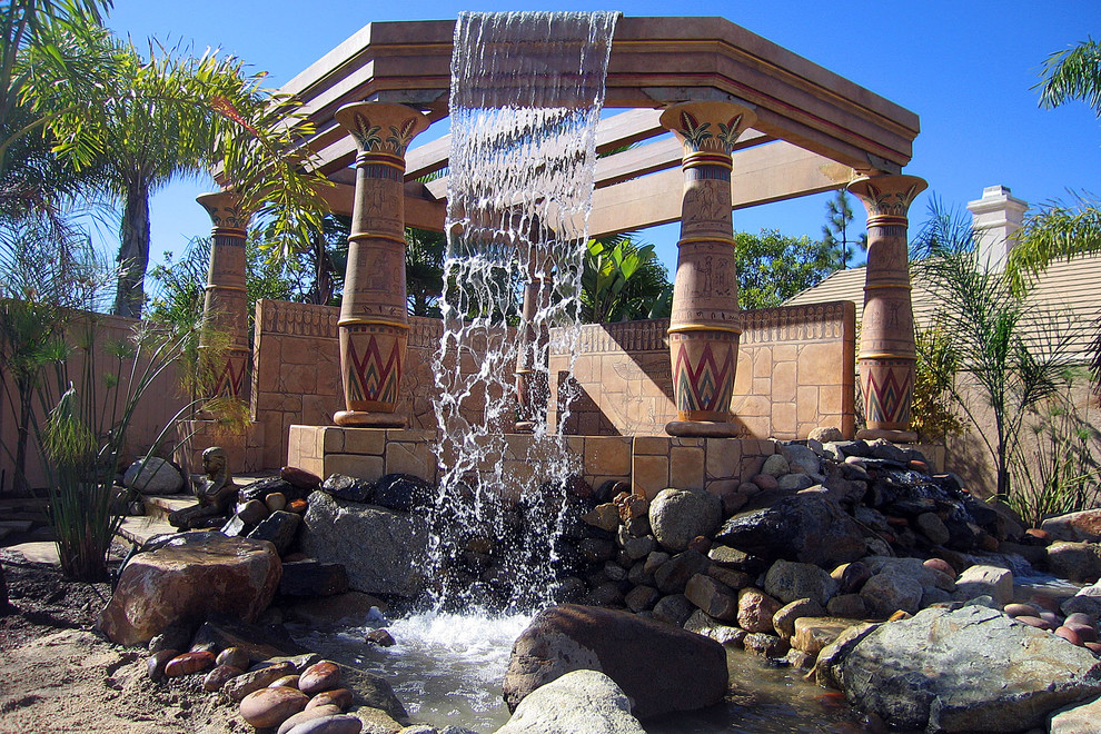 Photo of a medium sized world-inspired back partial sun garden in Orange County with a water feature.