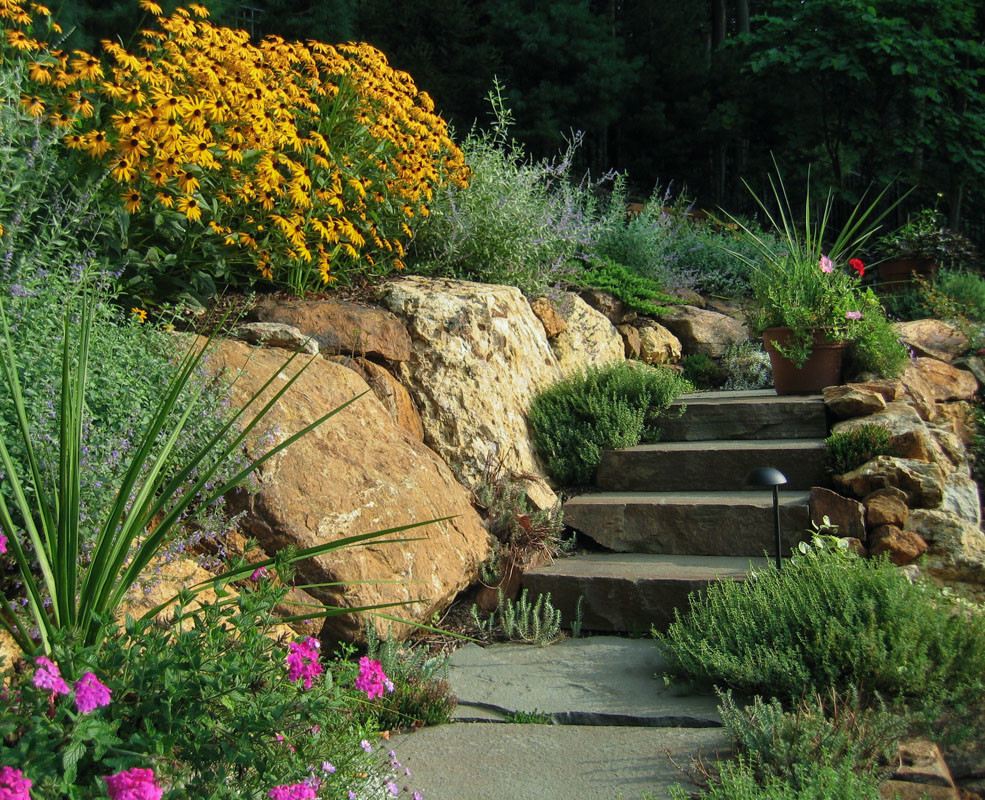 Esempio di un giardino formale tradizionale esposto in pieno sole di medie dimensioni in estate con un ingresso o sentiero, un pendio, una collina o una riva e pavimentazioni in pietra naturale