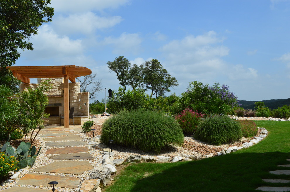 Immagine di un grande giardino design esposto a mezz'ombra con un focolare e pavimentazioni in pietra naturale