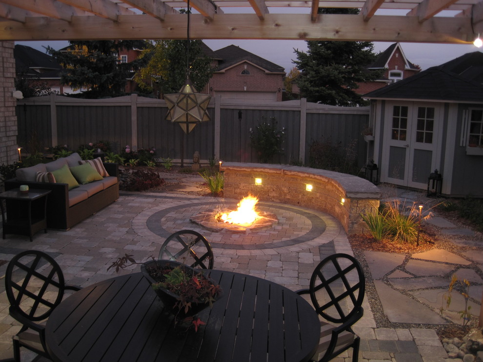Example of a small trendy backyard concrete paver patio design in Toronto with a fire pit