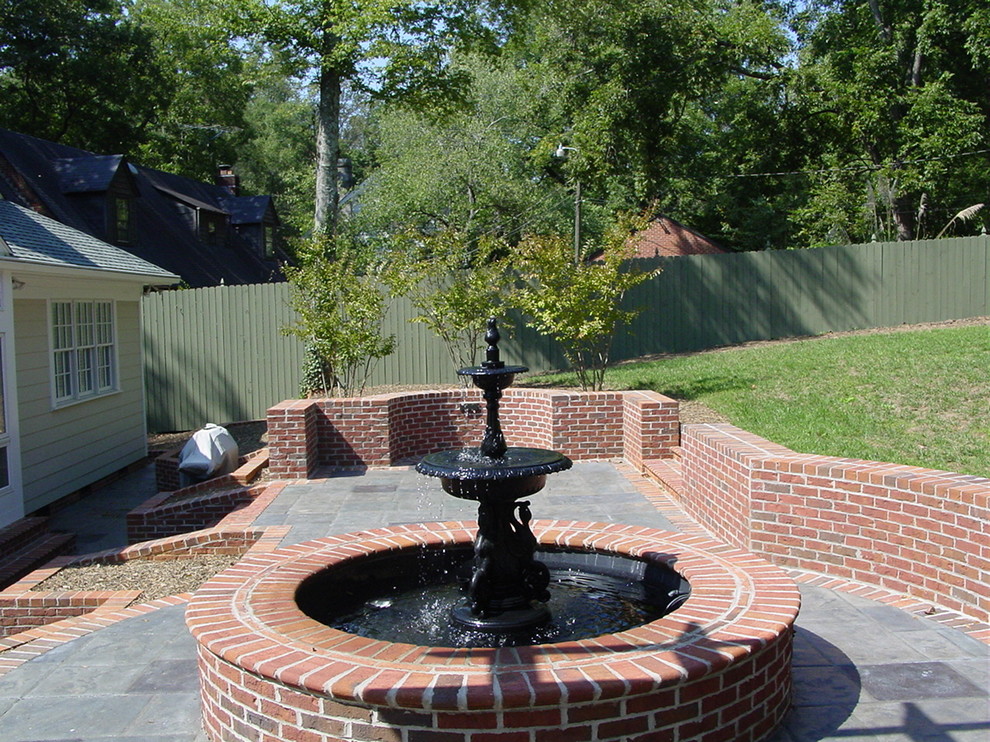 Inspiration for a large classic back full sun garden in Other with a retaining wall and brick paving.