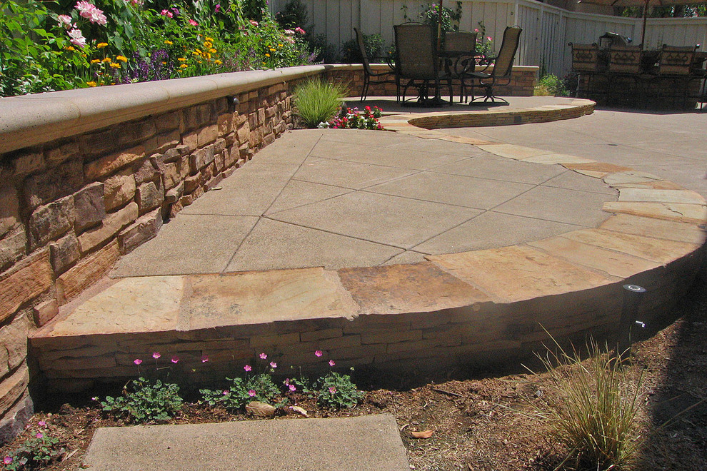 Photo of a medium sized traditional back partial sun garden for summer in Orange County with a retaining wall and natural stone paving.