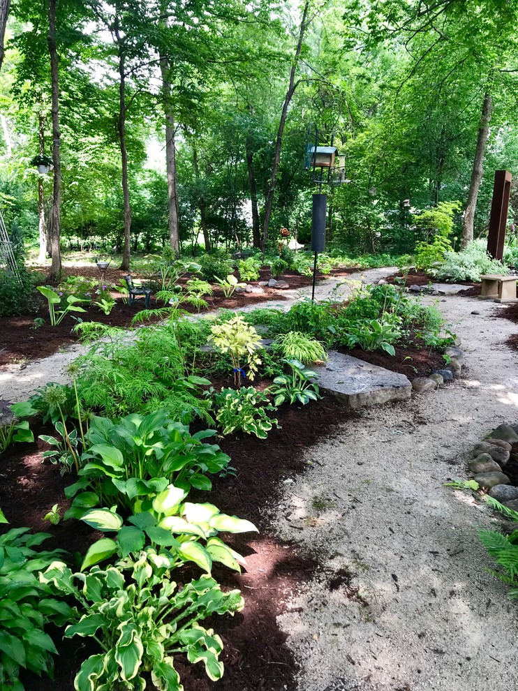 Photo of a large classic back xeriscape fully shaded garden for summer in Chicago with a garden path and gravel.