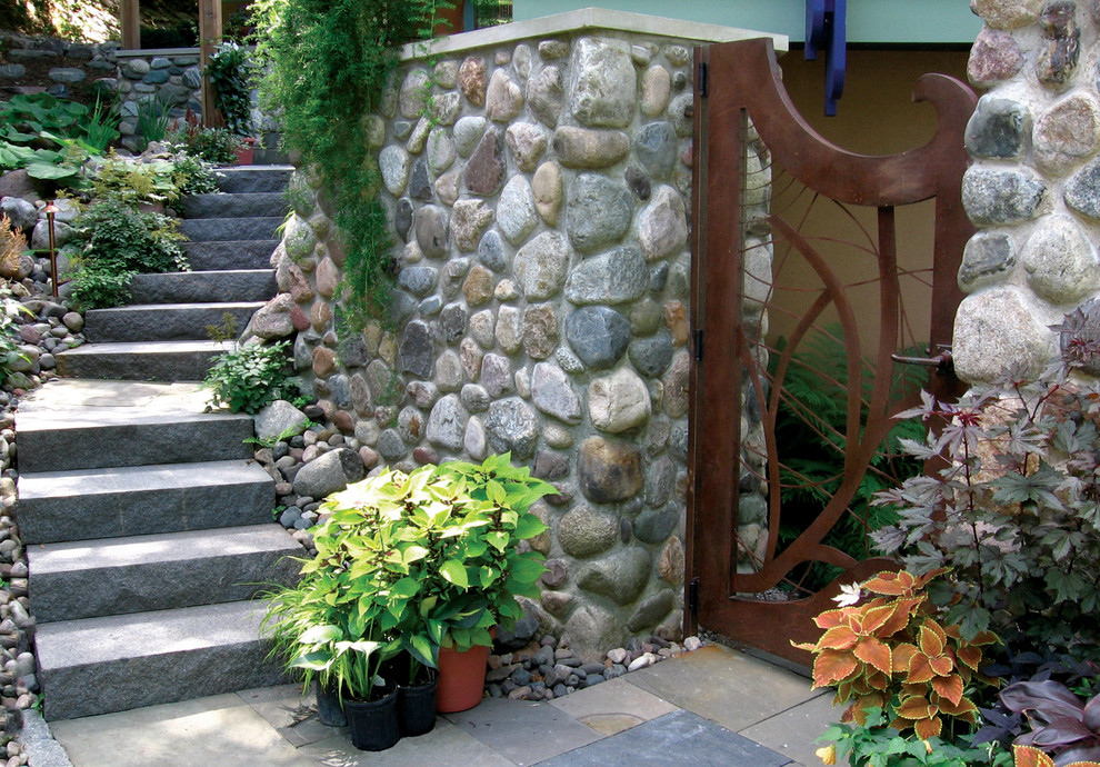 Exempel på en mellanstor klassisk trädgård framför huset, med en trädgårdsgång och naturstensplattor