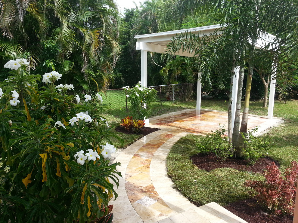Idee per un giardino tropicale esposto a mezz'ombra di medie dimensioni e dietro casa con pavimentazioni in pietra naturale