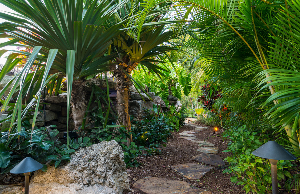 Modelo de camino de jardín tropical extra grande en verano en patio trasero con exposición parcial al sol y adoquines de piedra natural