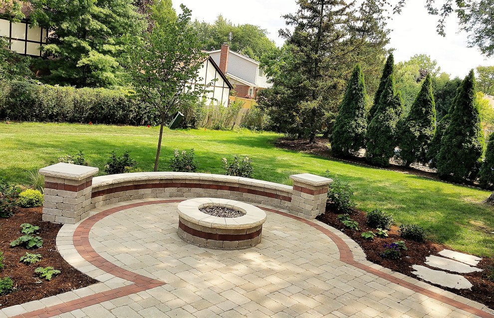 Esempio di un grande giardino classico esposto a mezz'ombra dietro casa con un focolare e pavimentazioni in cemento