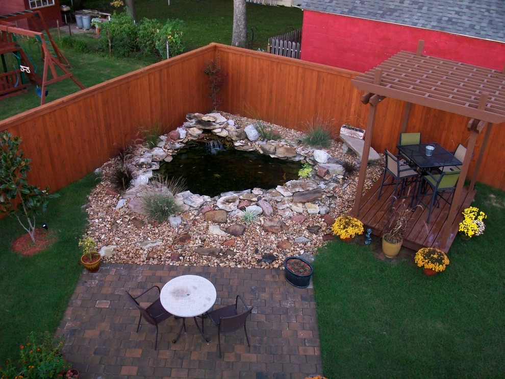 Foto de jardín rústico de tamaño medio en patio trasero con jardín francés, estanque, exposición total al sol y adoquines de ladrillo