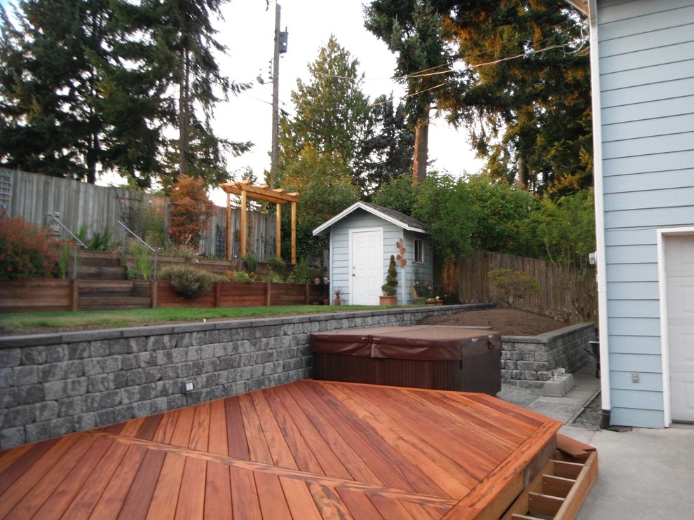 This is an example of a mid-sized transitional partial sun backyard landscaping in Seattle with decking for summer.