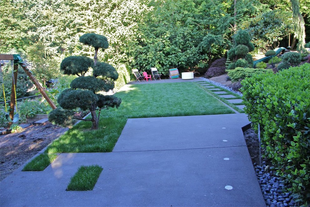 Foto de jardín clásico de tamaño medio en patio trasero con parque infantil, exposición parcial al sol y adoquines de hormigón