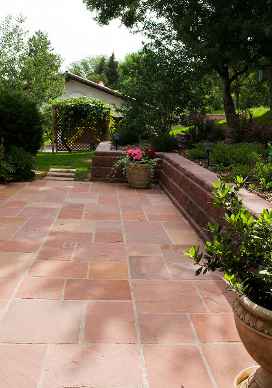 На фото: большой участок и сад на заднем дворе в современном стиле с подпорной стенкой, полуденной тенью и покрытием из каменной брусчатки