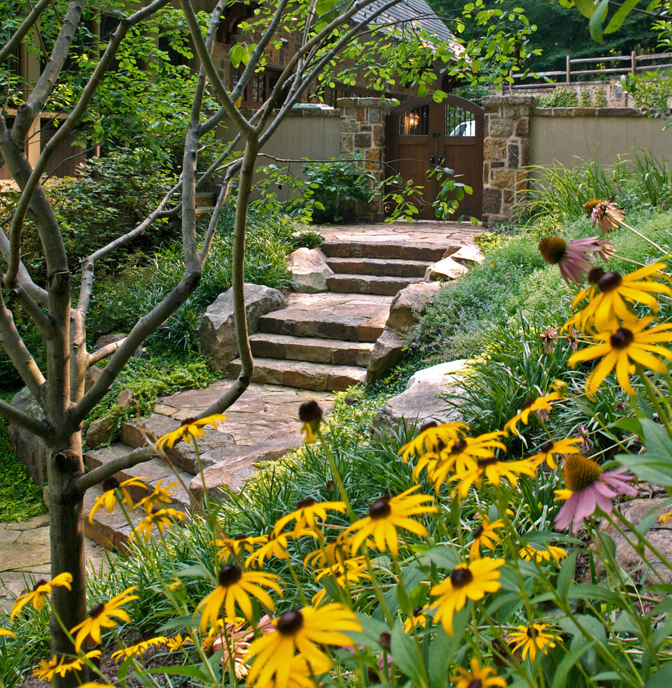 Exemple d'un jardin tendance avec une pente, une colline ou un talus et des pavés en pierre naturelle.