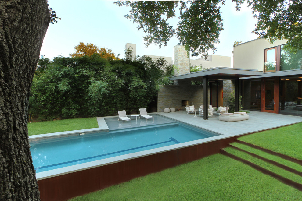 Cette image montre un grand jardin arrière minimaliste avec un foyer extérieur et une exposition partiellement ombragée.