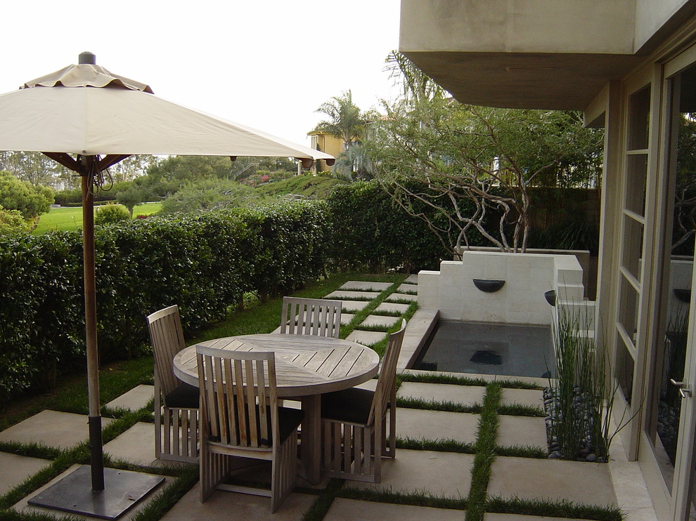 Immagine di un giardino design esposto a mezz'ombra di medie dimensioni e dietro casa in primavera con pavimentazioni in cemento