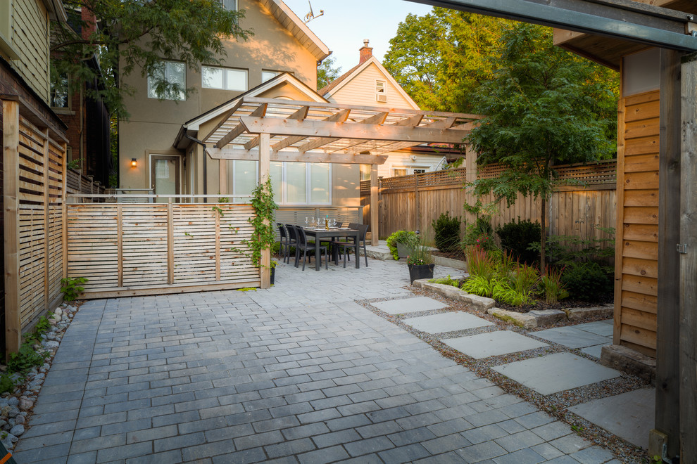 На фото: маленький участок и сад на заднем дворе в стиле модернизм с подъездной дорогой, полуденной тенью и мощением тротуарной плиткой для на участке и в саду