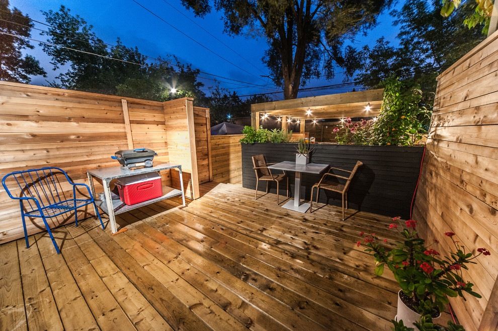 Design ideas for a small modern partial sun backyard landscaping in Toronto with decking for summer.