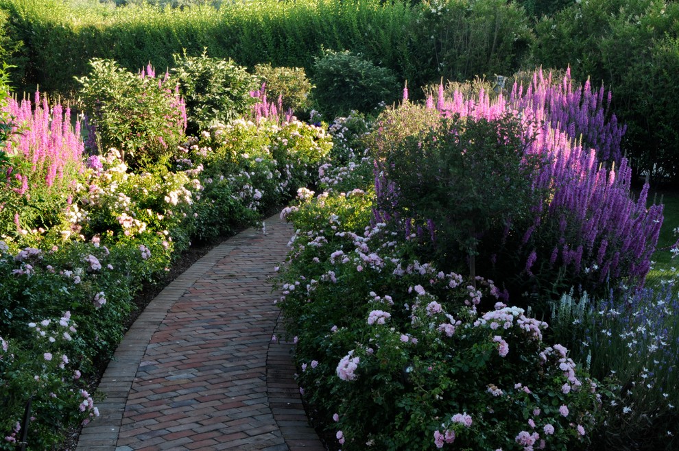 Inspiration for a large traditional partial sun backyard brick landscaping in New York.