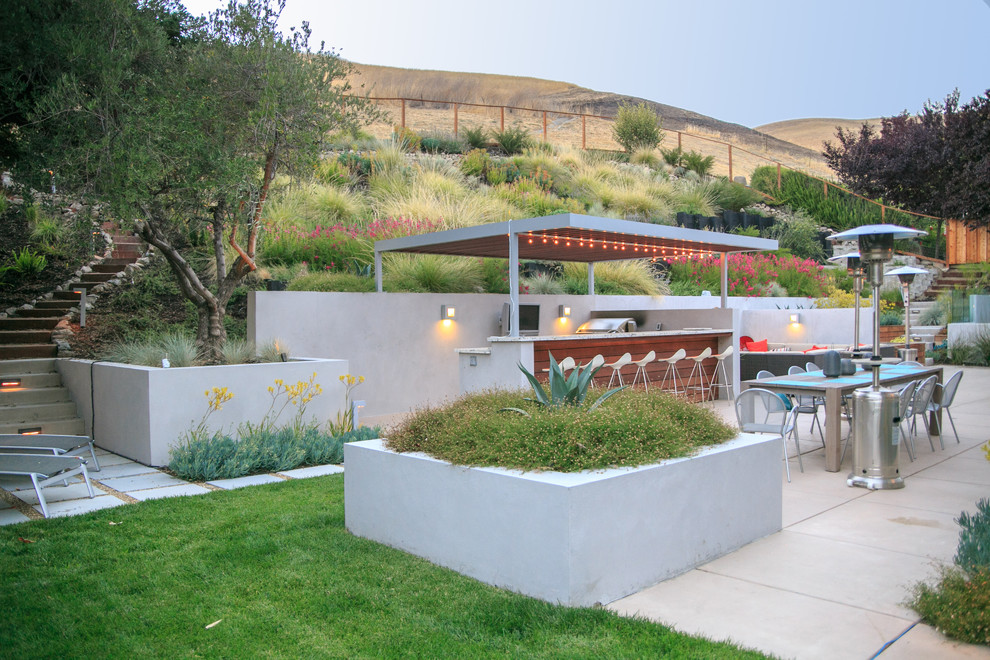 Пример оригинального дизайна: большой регулярный сад на склоне в современном стиле с мощением тротуарной плиткой