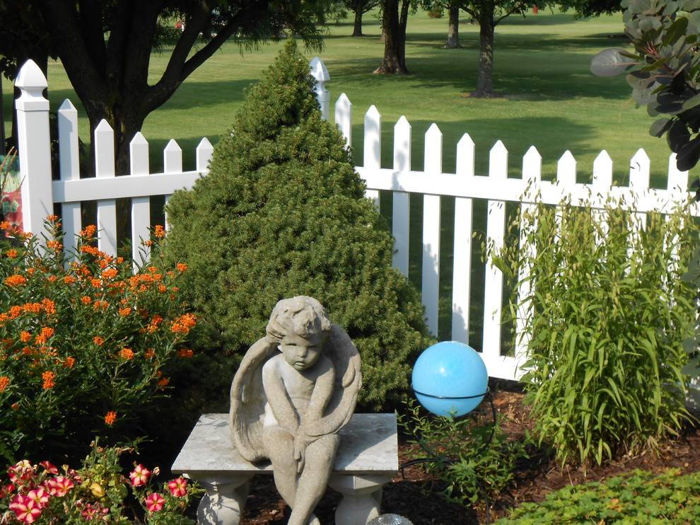 На фото: участок и сад на заднем дворе в викторианском стиле с полуденной тенью и мульчированием