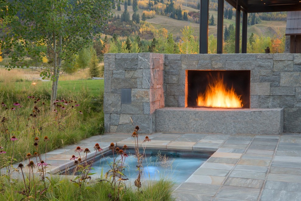 Large rural front formal full sun garden for autumn in Denver with a water feature and natural stone paving.