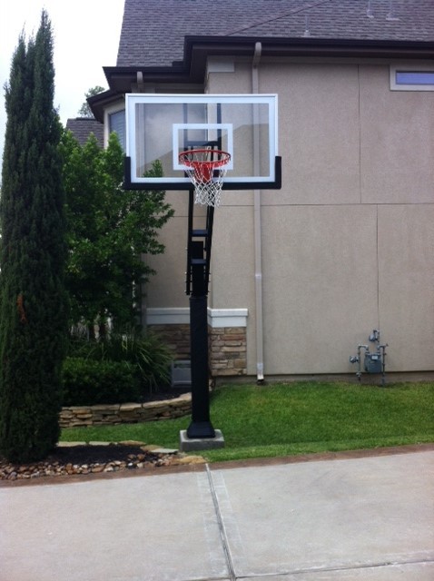 This is an example of a large traditional front partial sun garden in Houston with an outdoor sport court.