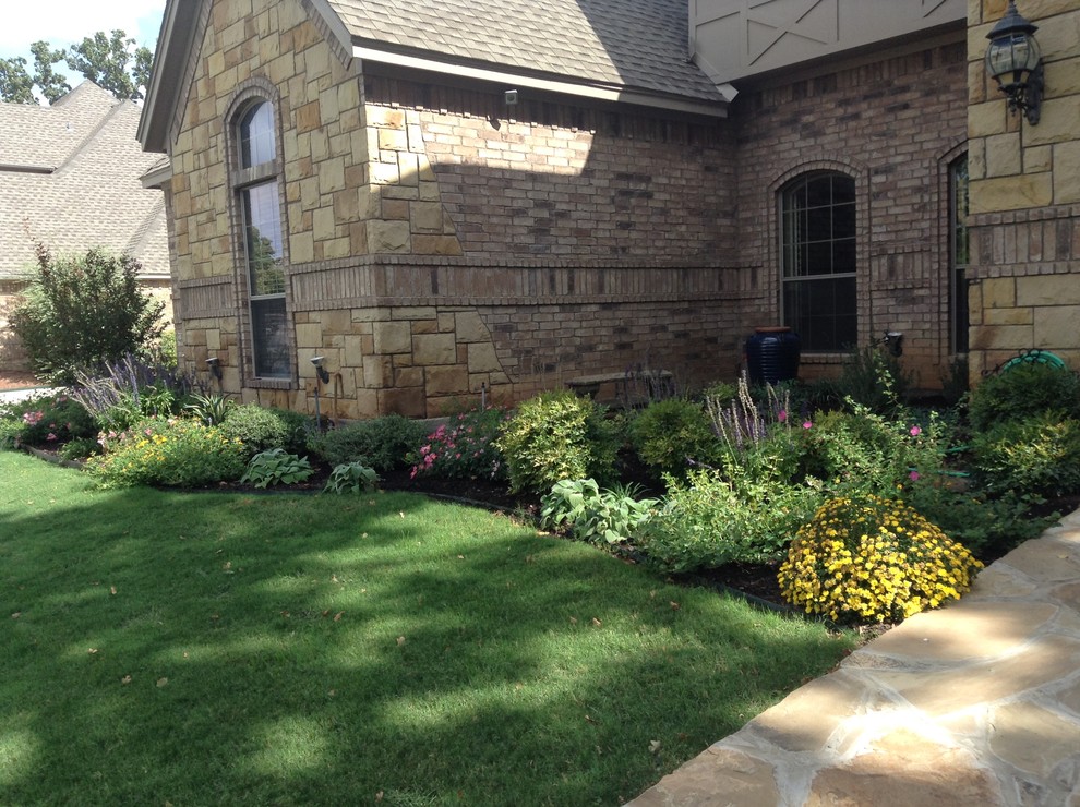 Idee per un grande giardino xeriscape american style esposto a mezz'ombra davanti casa in primavera con pacciame