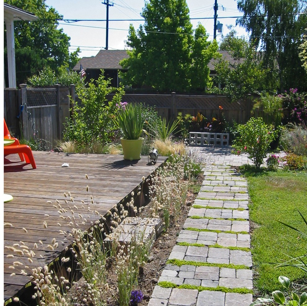 Immagine di un giardino contemporaneo dietro casa con pavimentazioni in mattoni e scale