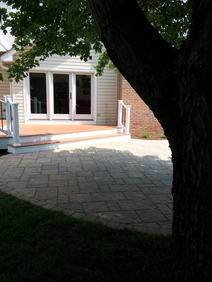 This is an example of a mid-sized transitional full sun backyard concrete paver landscaping in Baltimore.
