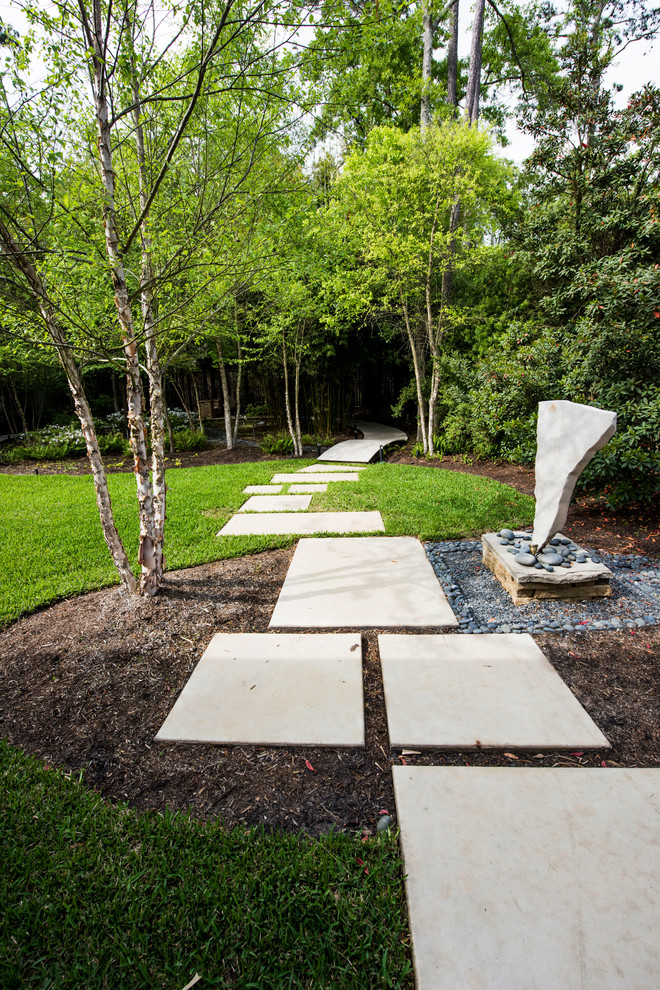 This is an example of a medium sized modern side partial sun garden for spring in Houston with a garden path and concrete paving.