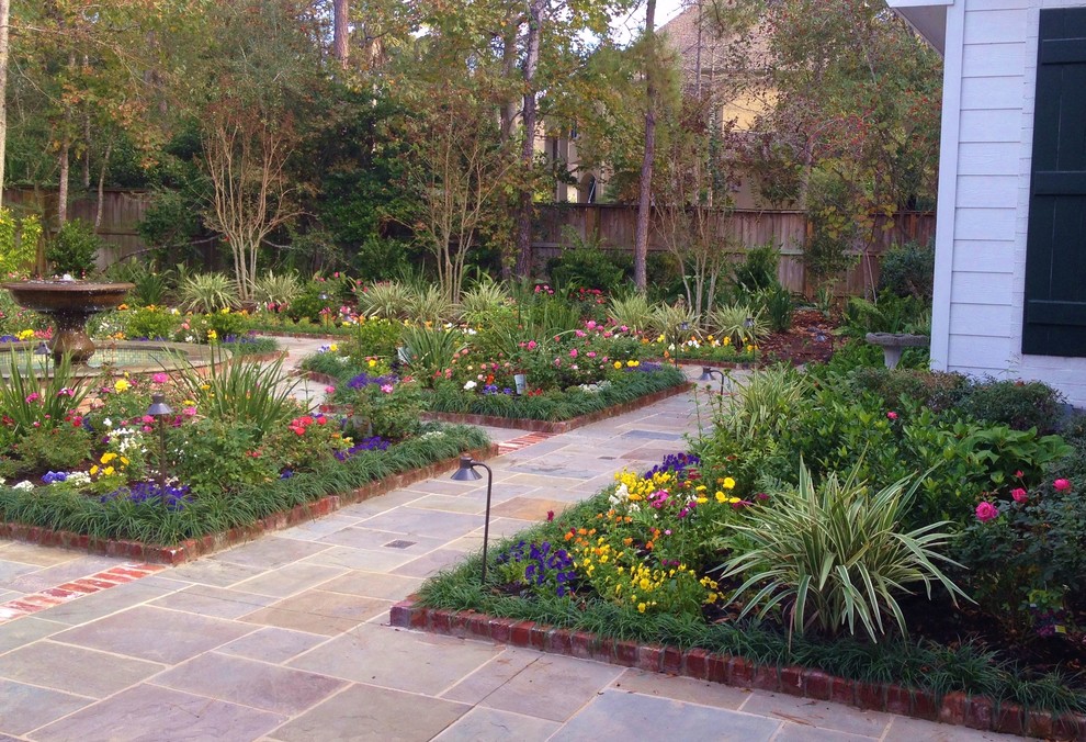 Modelo de jardín clásico grande en primavera en patio trasero con fuente, exposición parcial al sol y adoquines de piedra natural