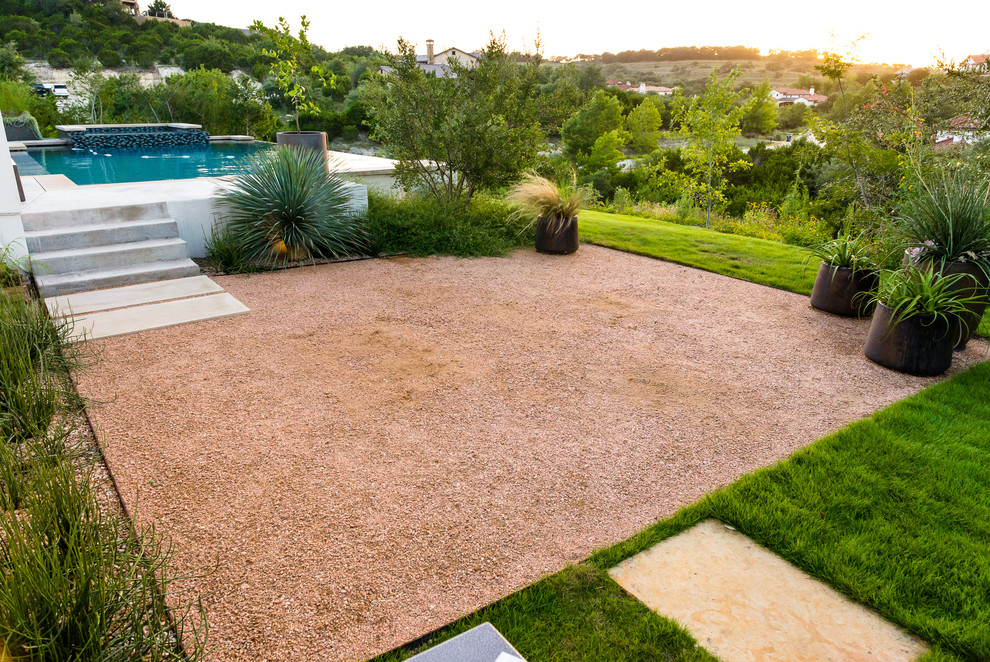 Inspiration for a large contemporary drought-tolerant, full sun and desert backyard gravel landscaping in Austin.