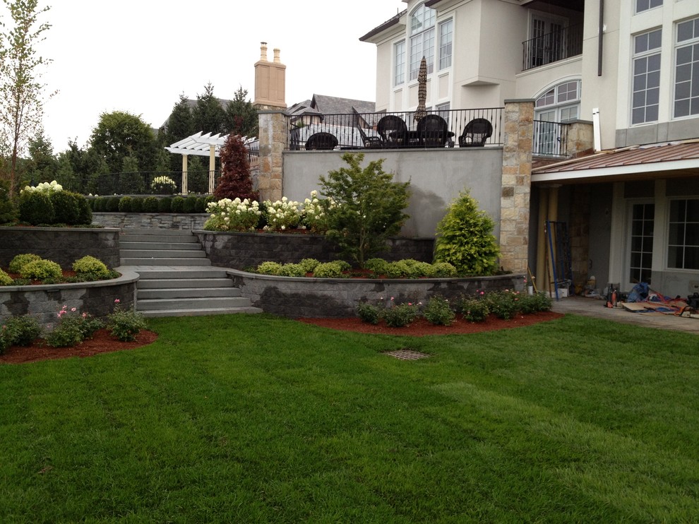 Esempio di un ampio giardino formale chic dietro casa con pavimentazioni in pietra naturale