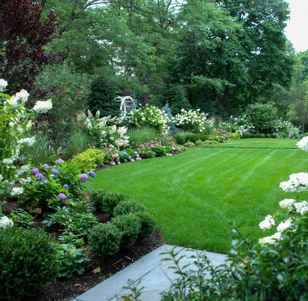 This is an example of a mid-sized traditional full sun front yard stone formal garden in Boston.