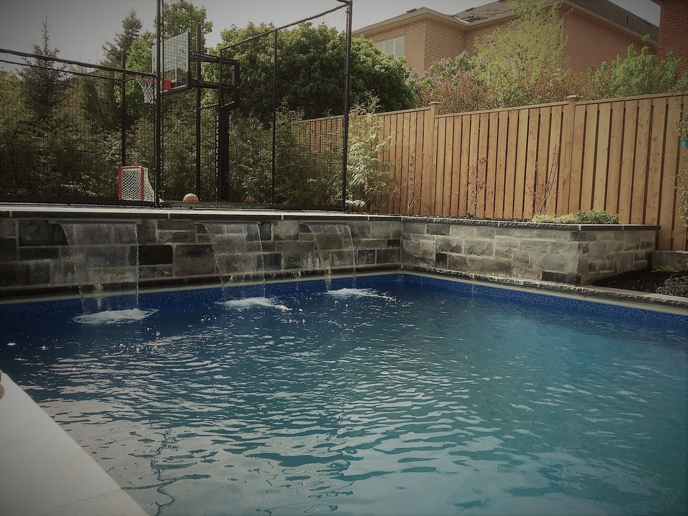 Immagine di una piscina minimalista di medie dimensioni e dietro casa con pavimentazioni in pietra naturale